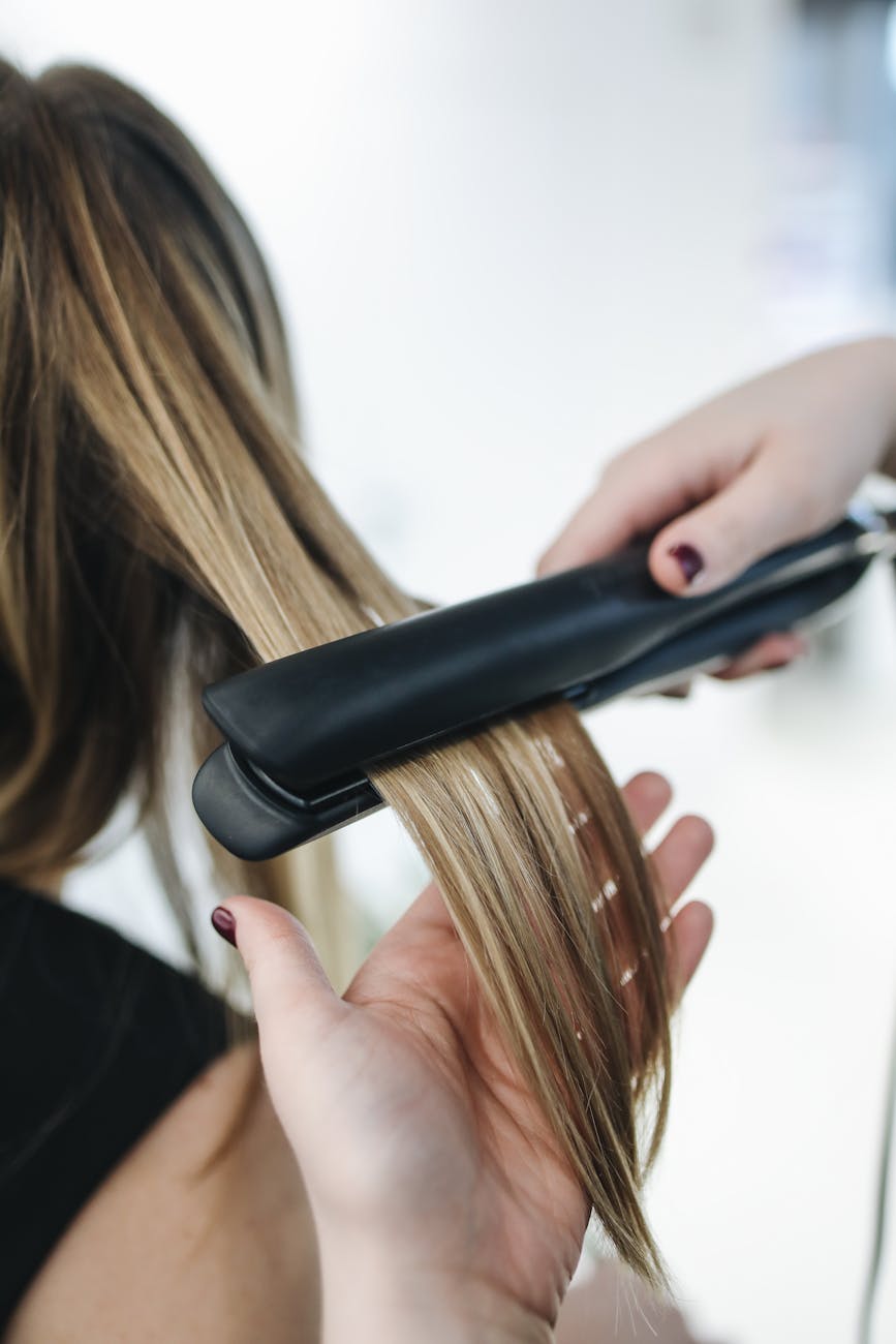 person ironing a woman s hair